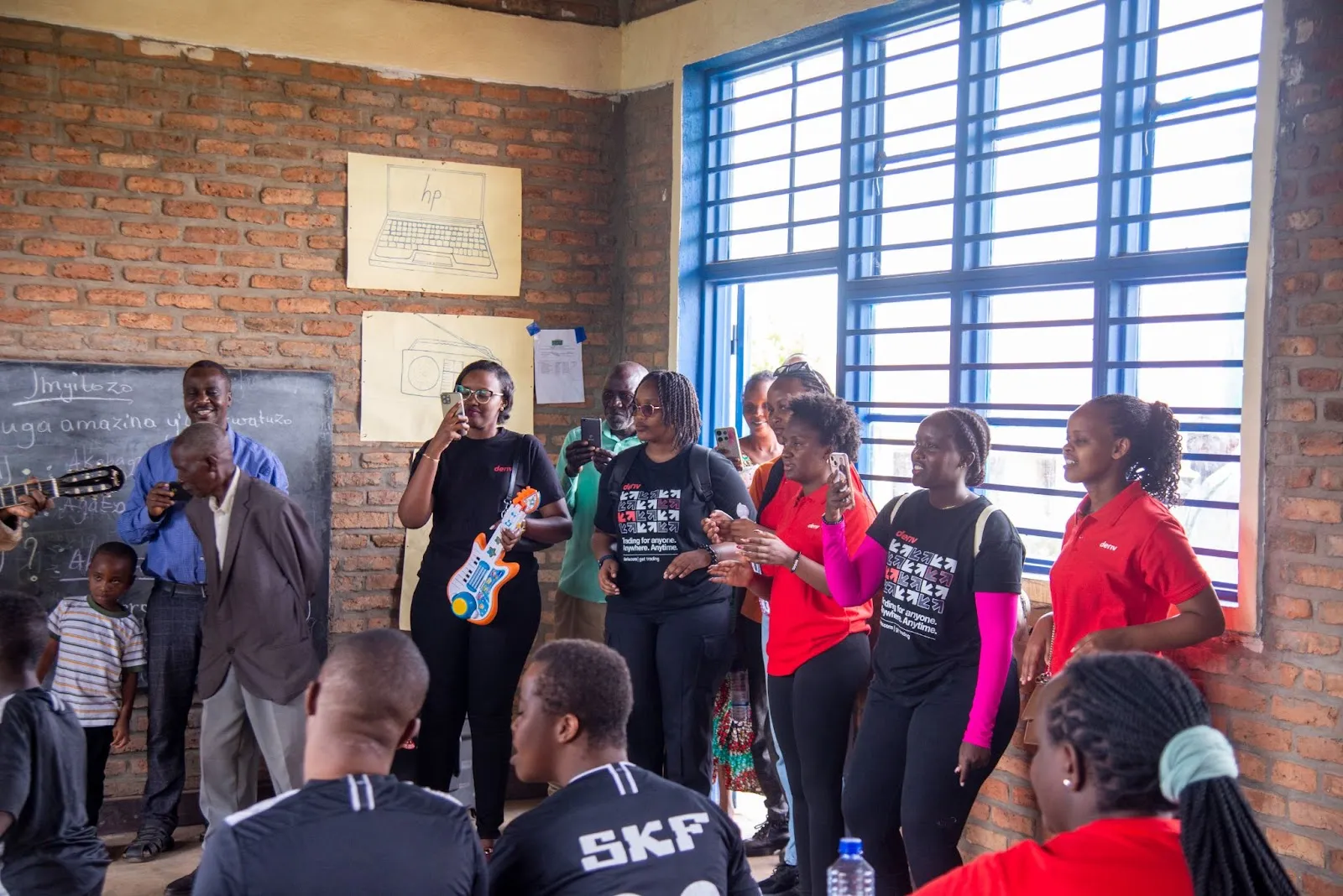 Deriv volunteer joining a rhythmic music session to encourage student self-expression and social engagement.