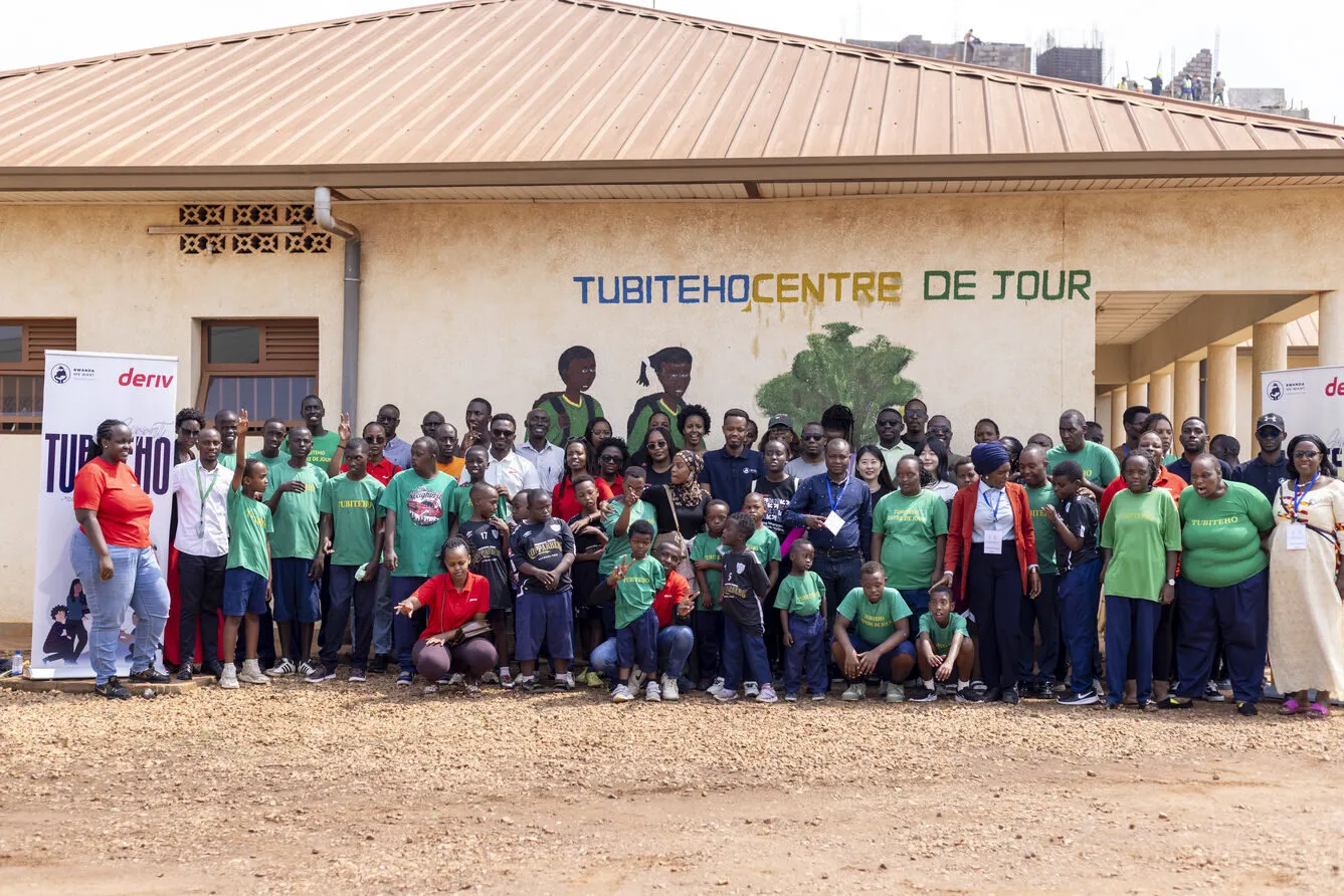 Deriv volunteers and students at Tubiteho School in Kigali, promoting inclusive education.