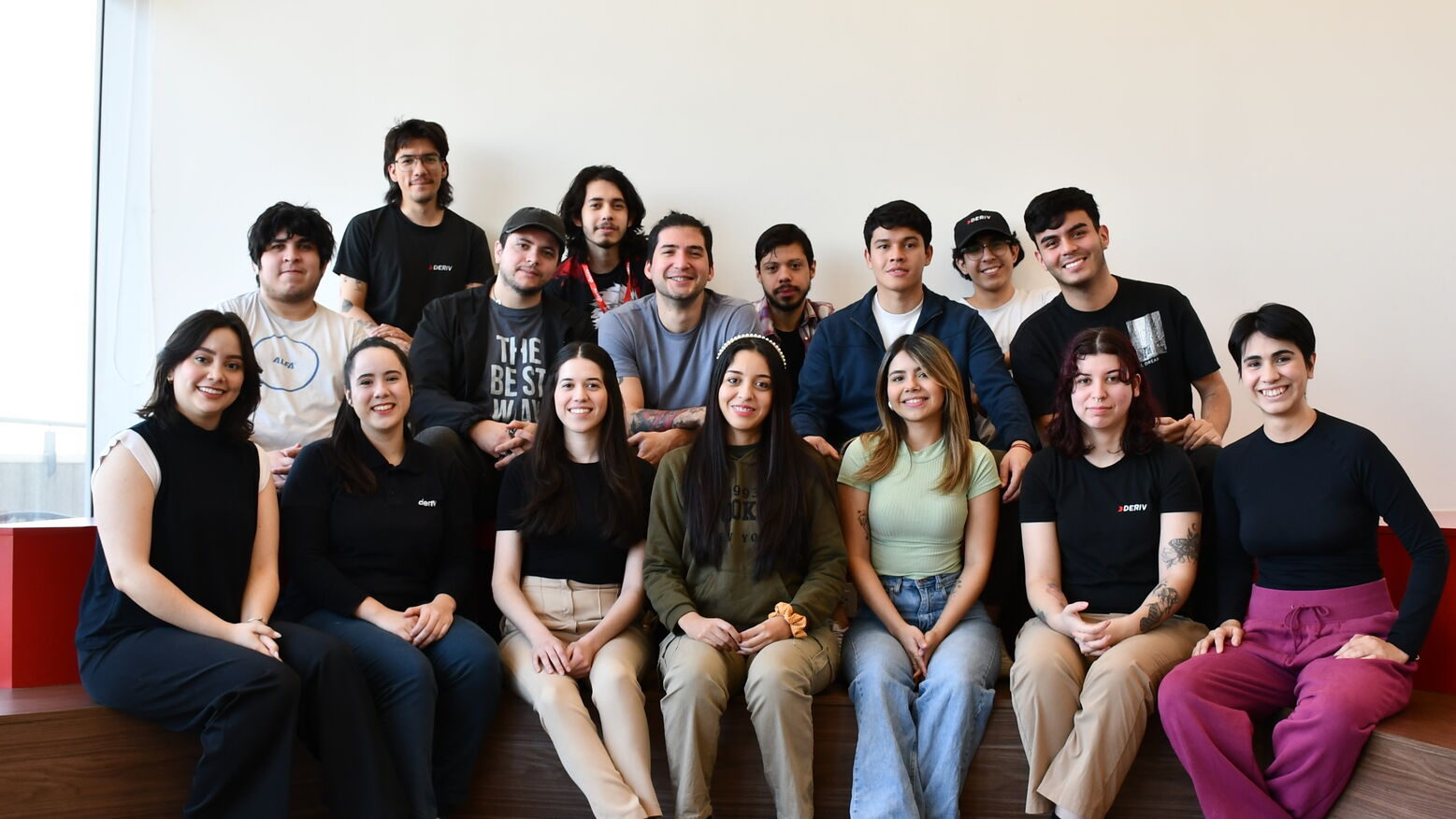 Deriv Paraguay team seated together for a group photo, showcasing a united and innovative workplace culture