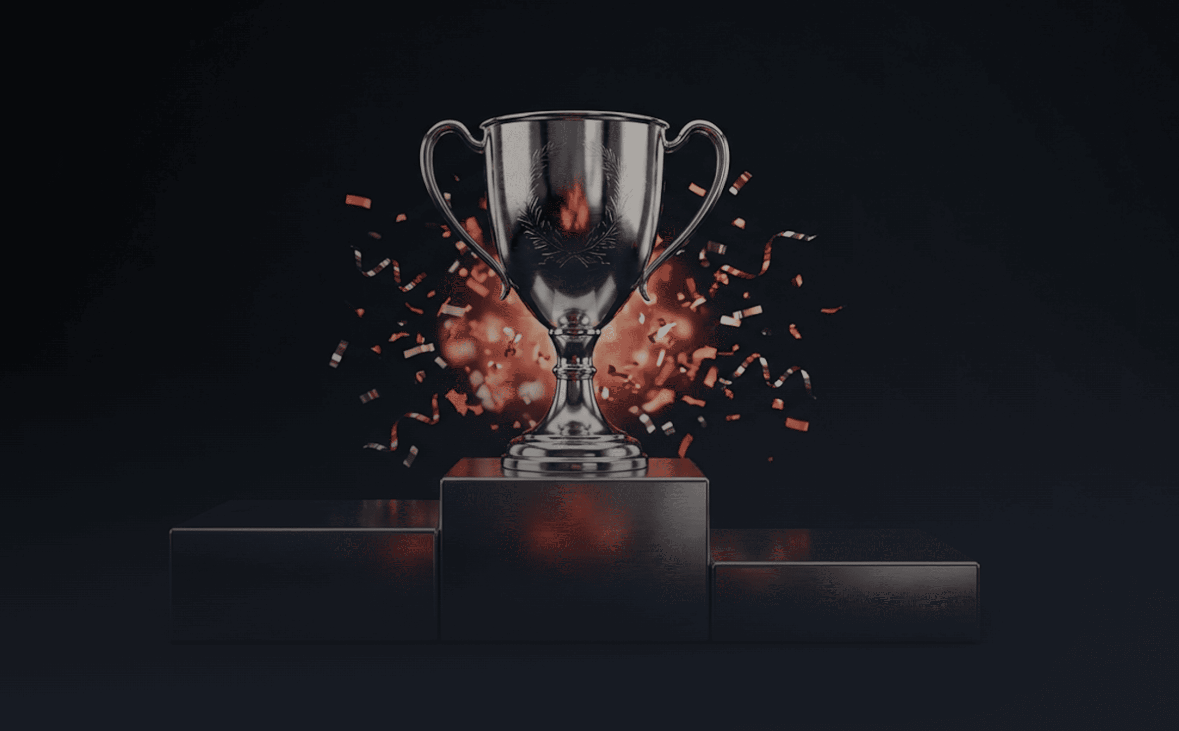 A silver trophy displayed on a central podium against a dark background, illuminated by soft light.