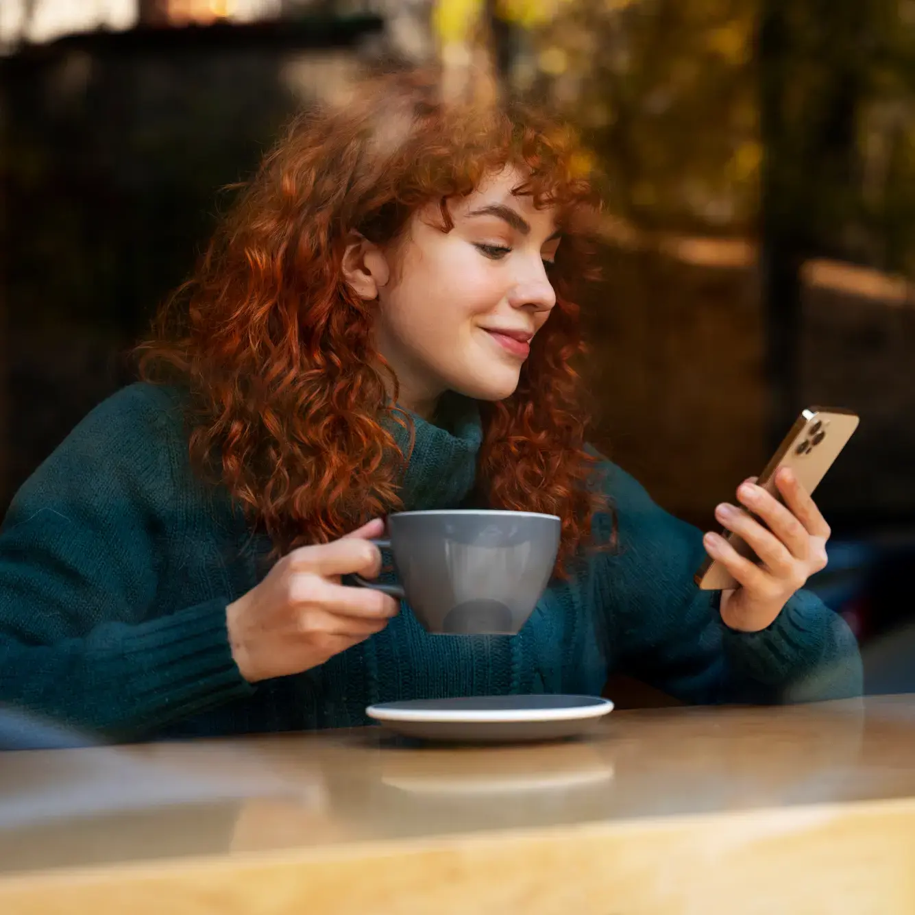 A female trader checking Deriv's XRP trading platform on mobile device at a cafe