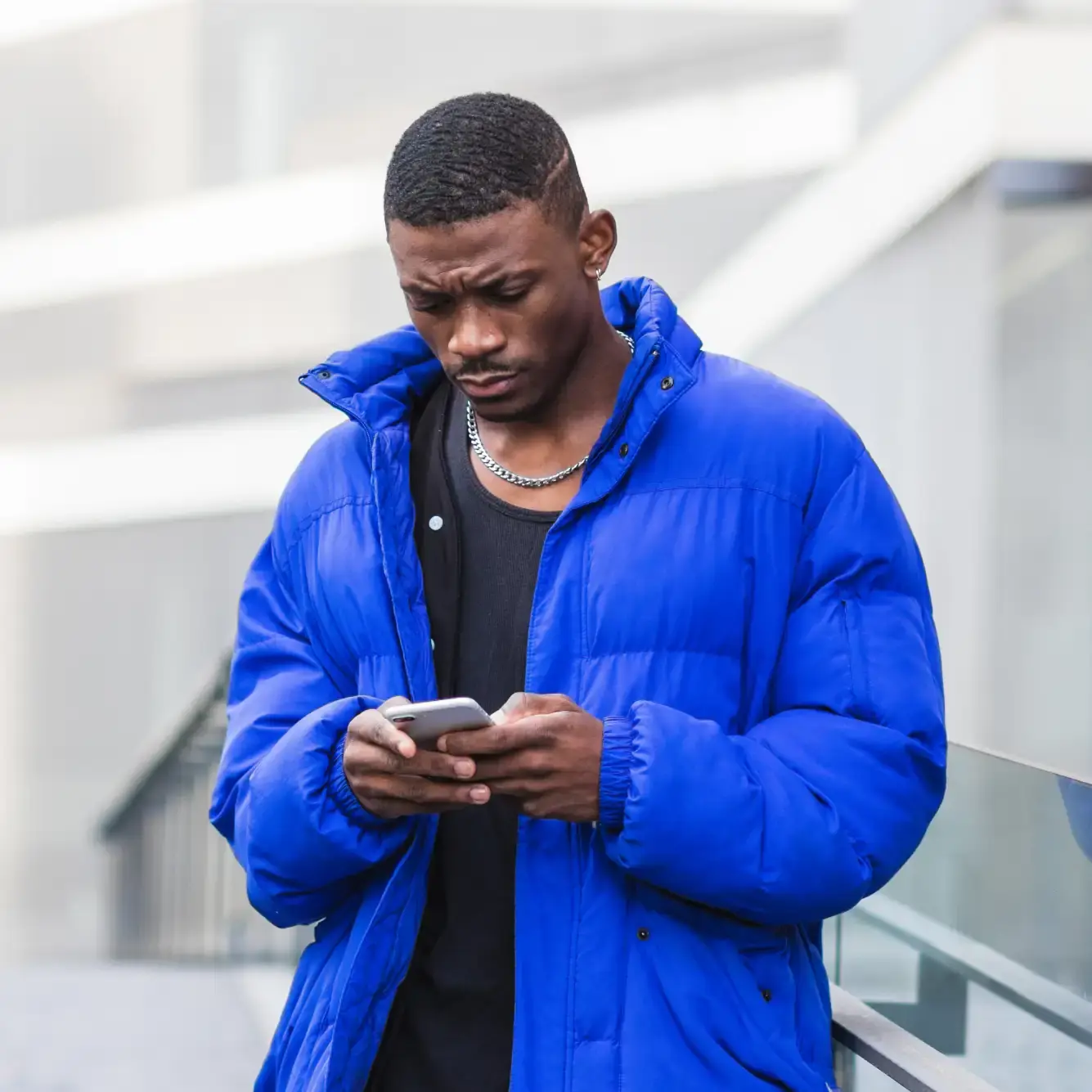 Trader a monitorizar os movimentos dos preços do petróleo numa aplicação de negociação Deriv no smartphone