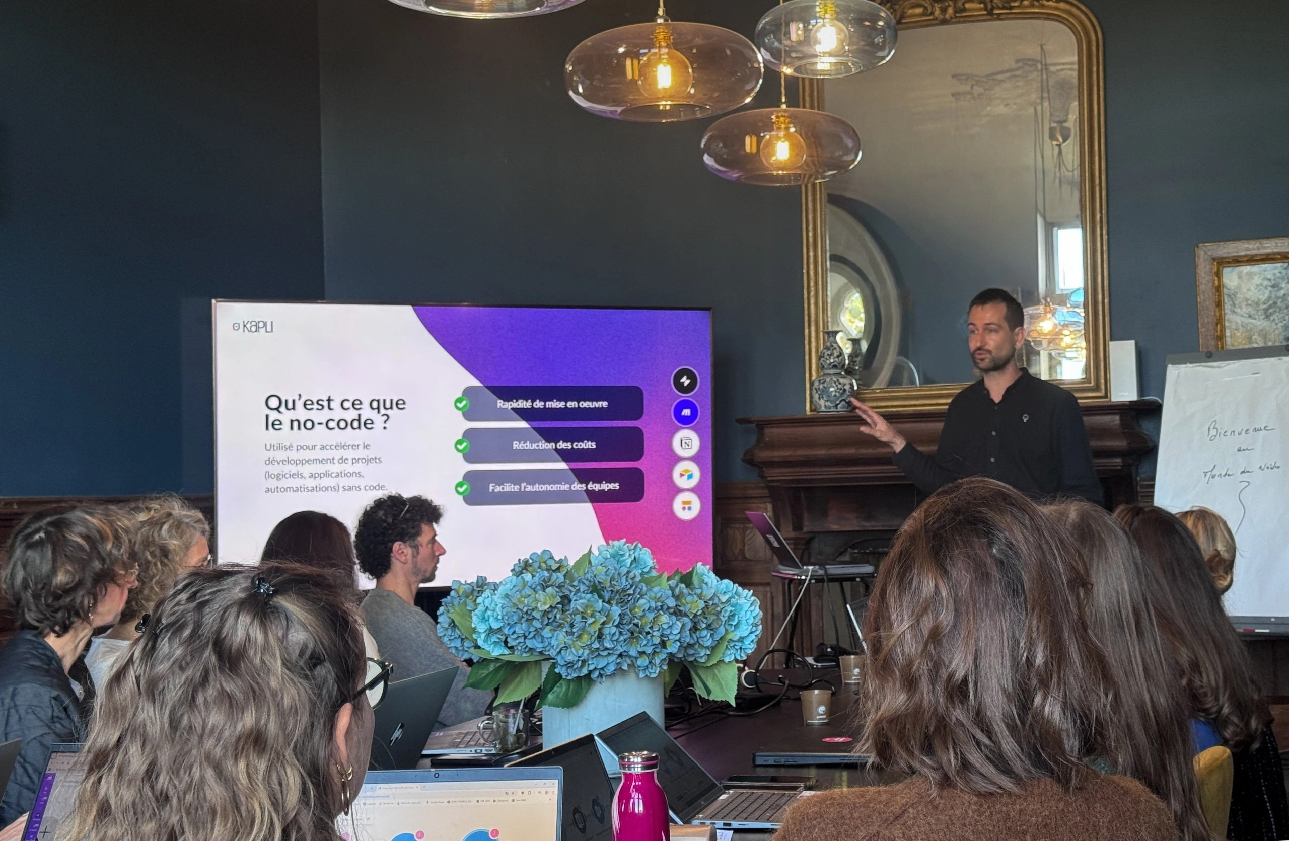 Atelier de formation no-code animé par l’agence Kapli, avec démonstration d’outils comme Make et Glide devant un groupe de participants avec Vénétis