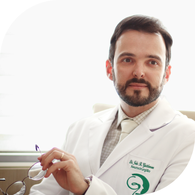 Dr. João Guttierrez em pé, de braços cruzados sorrindo na clínica guttierrez