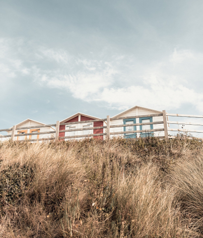 Beach huts a long grass
