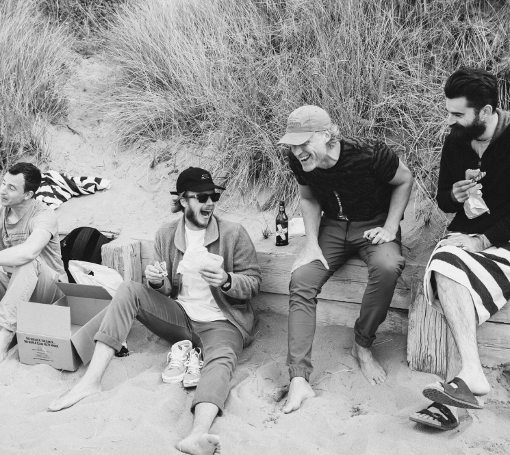 Group of men eating on a beach