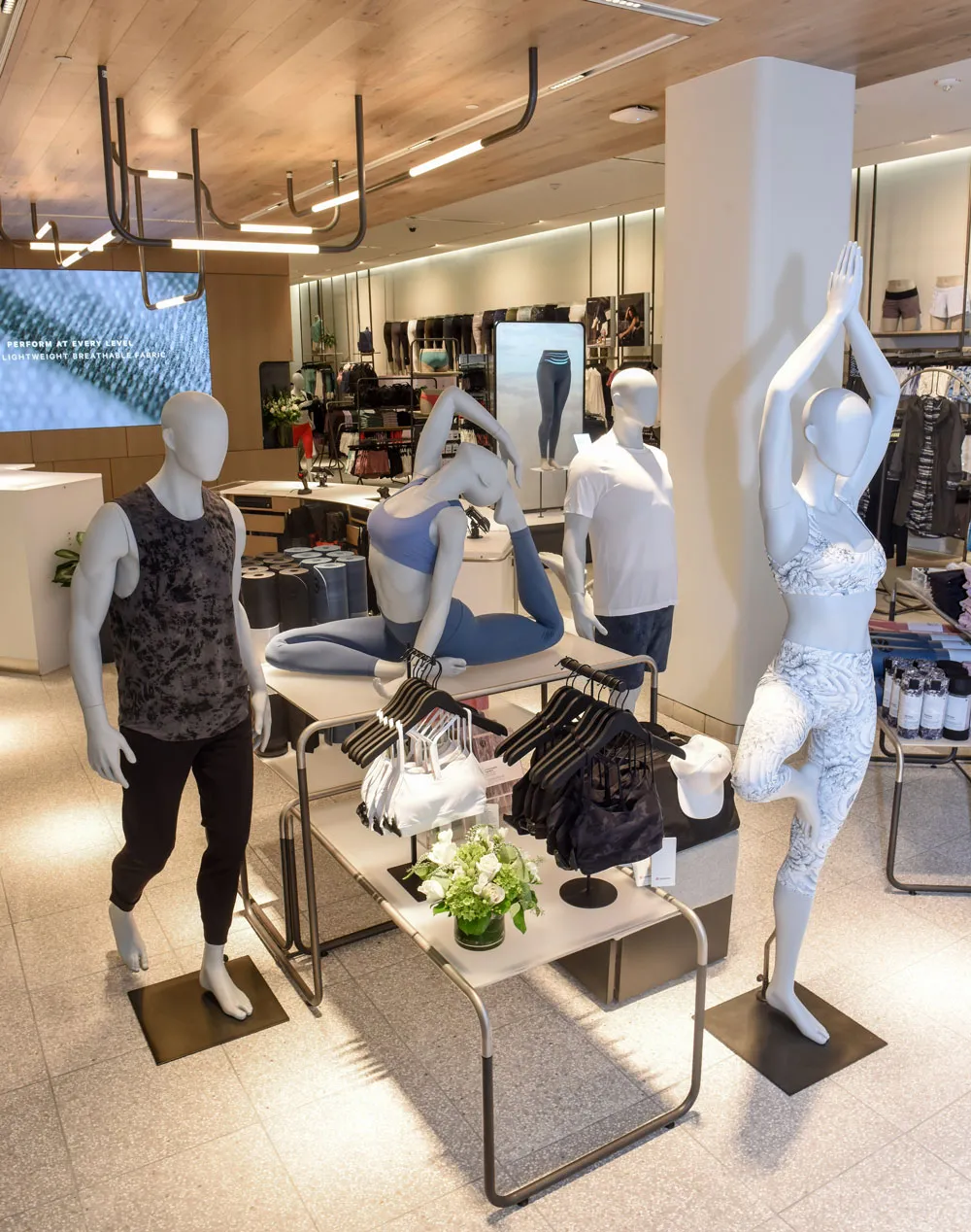 Lululemon retail store interior with contemporary fixtures, apparel displays, and mannequins in light-filled showroom
