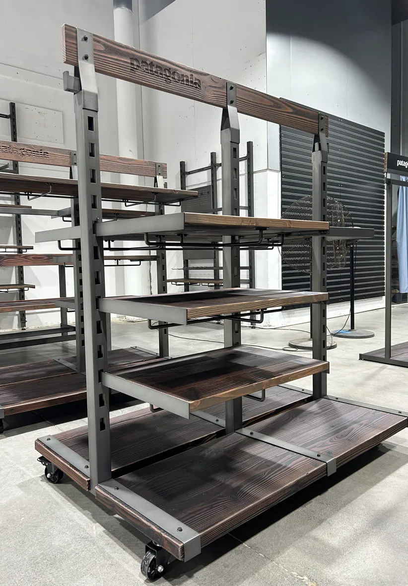 Custom Patagonia retail fixture with metal frame structure, steel stairs, and industrial shelving during assembly in manufacturing facility