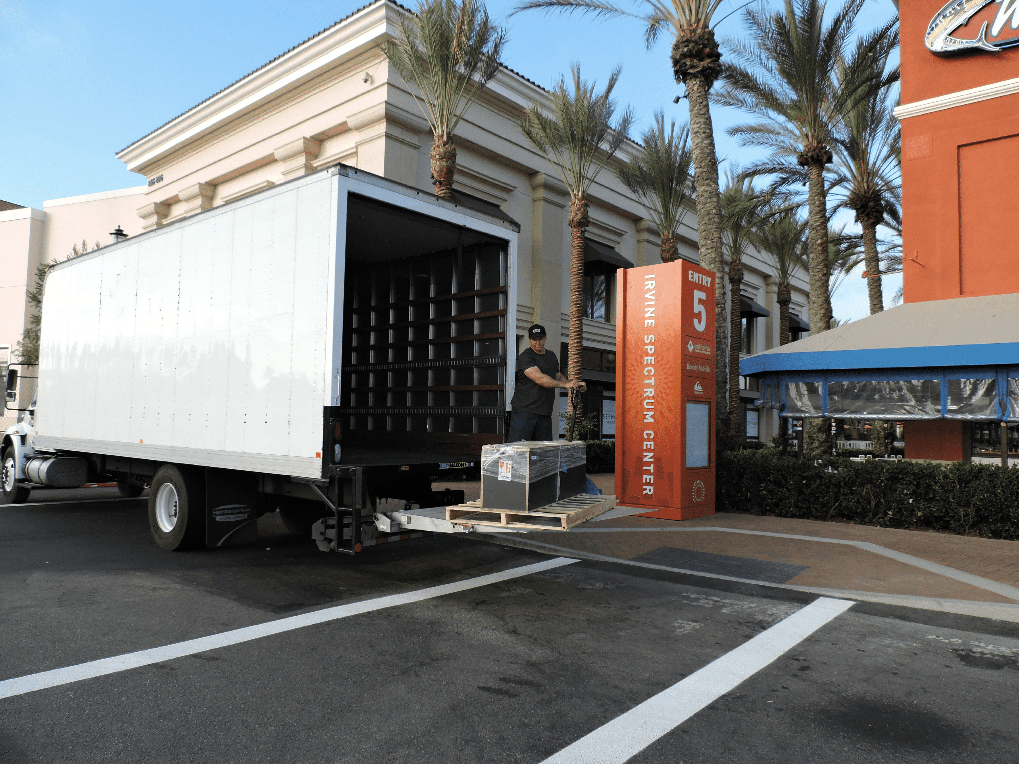 Retail store installation delivery with truck and crate unloading at storefront location