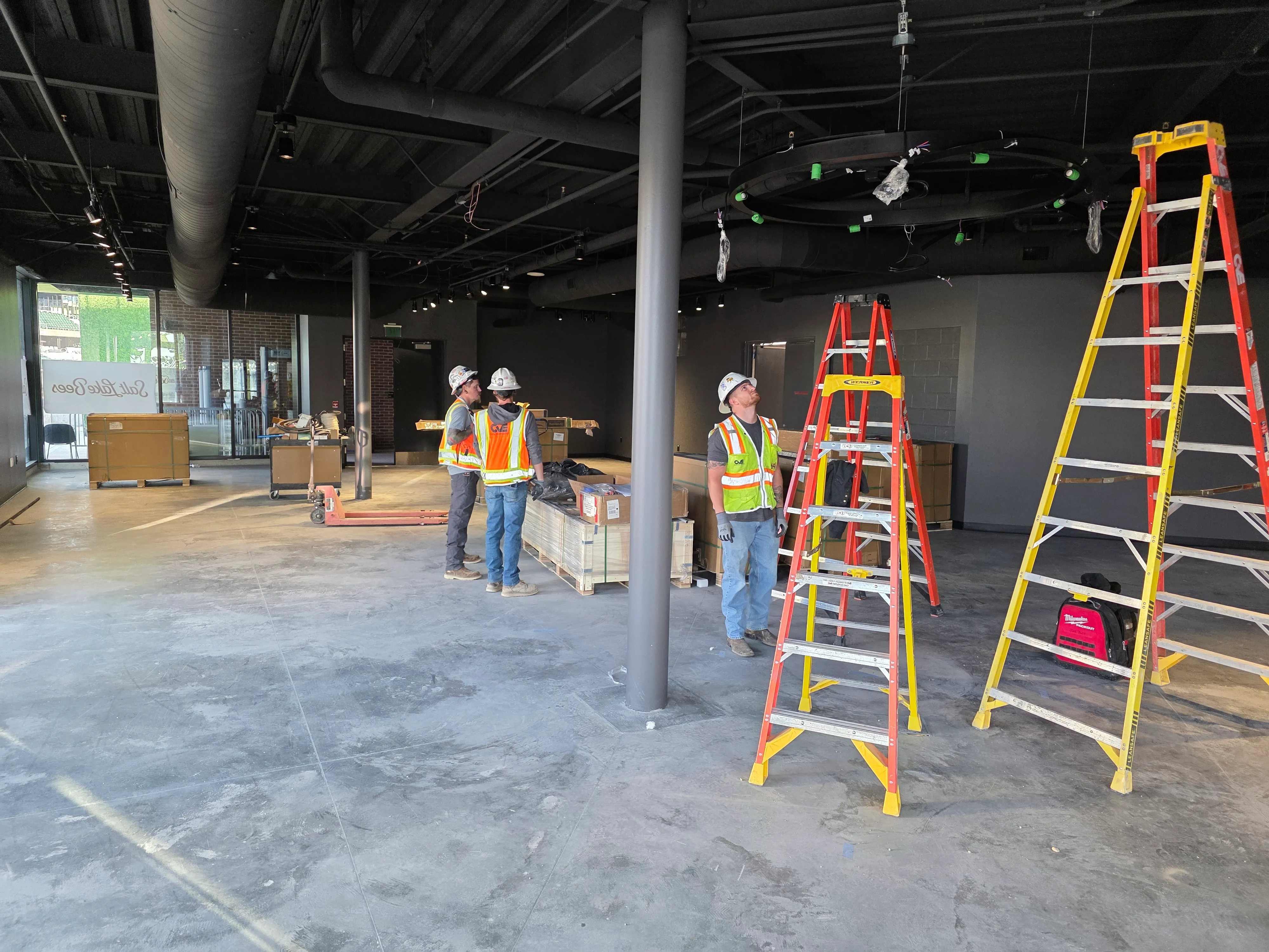 Seattle Kraken team store installation at Climate Pledge Arena with installation crew, scaffolding, and buildout in progress