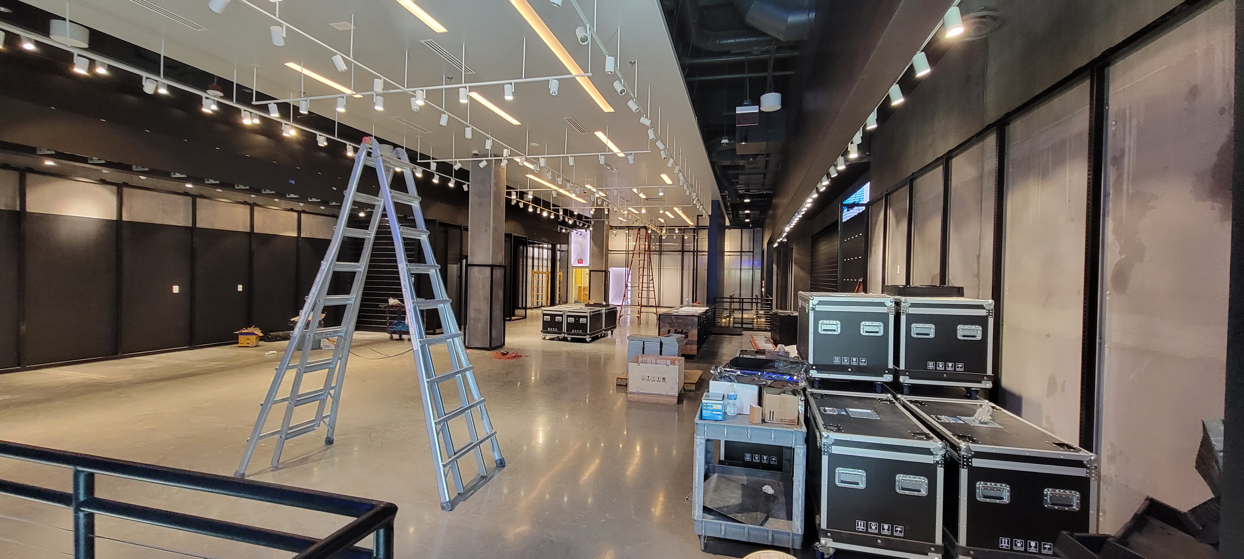 Lids NBA retail store in-progress installation with fixtures, electrical systems, ladders, and construction materials in large format space