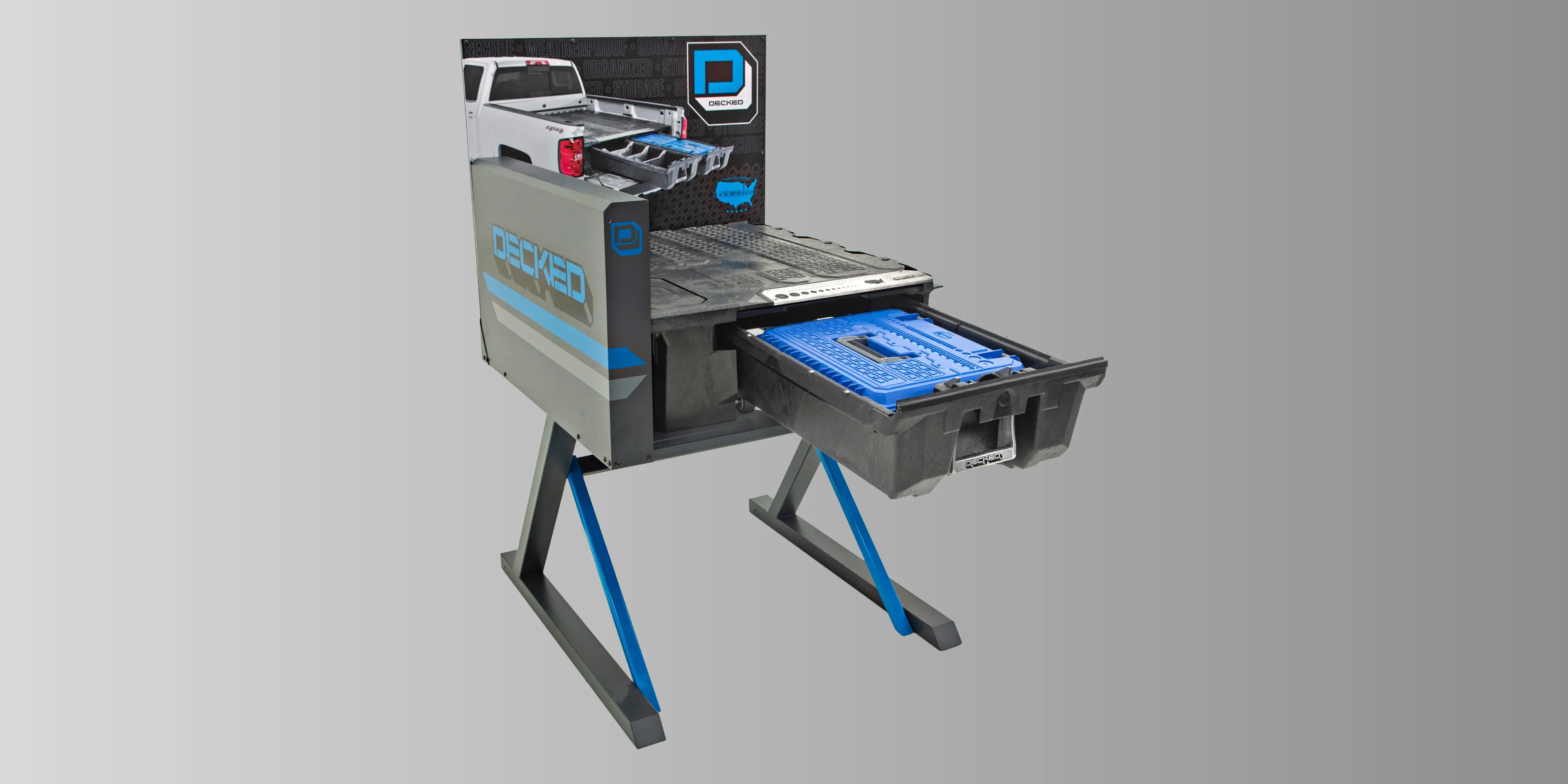 Decked Cargo Glide Display mobile equipment fixture with blue and black branding and pull-out drawer system