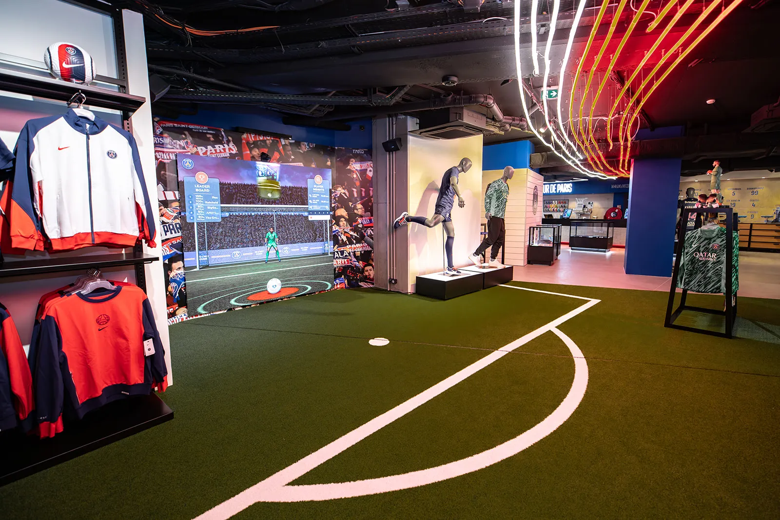 Paris Saint-Germain PSG retail experiential space with soccer field turf, interactive displays, branded signage, and neon accents
