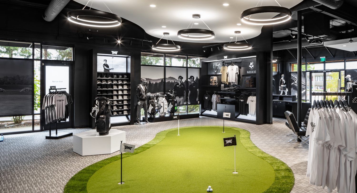 PXG Performance Studio retail floor featuring premium apparel displays, putting green integration, and customer flow-focused store layout