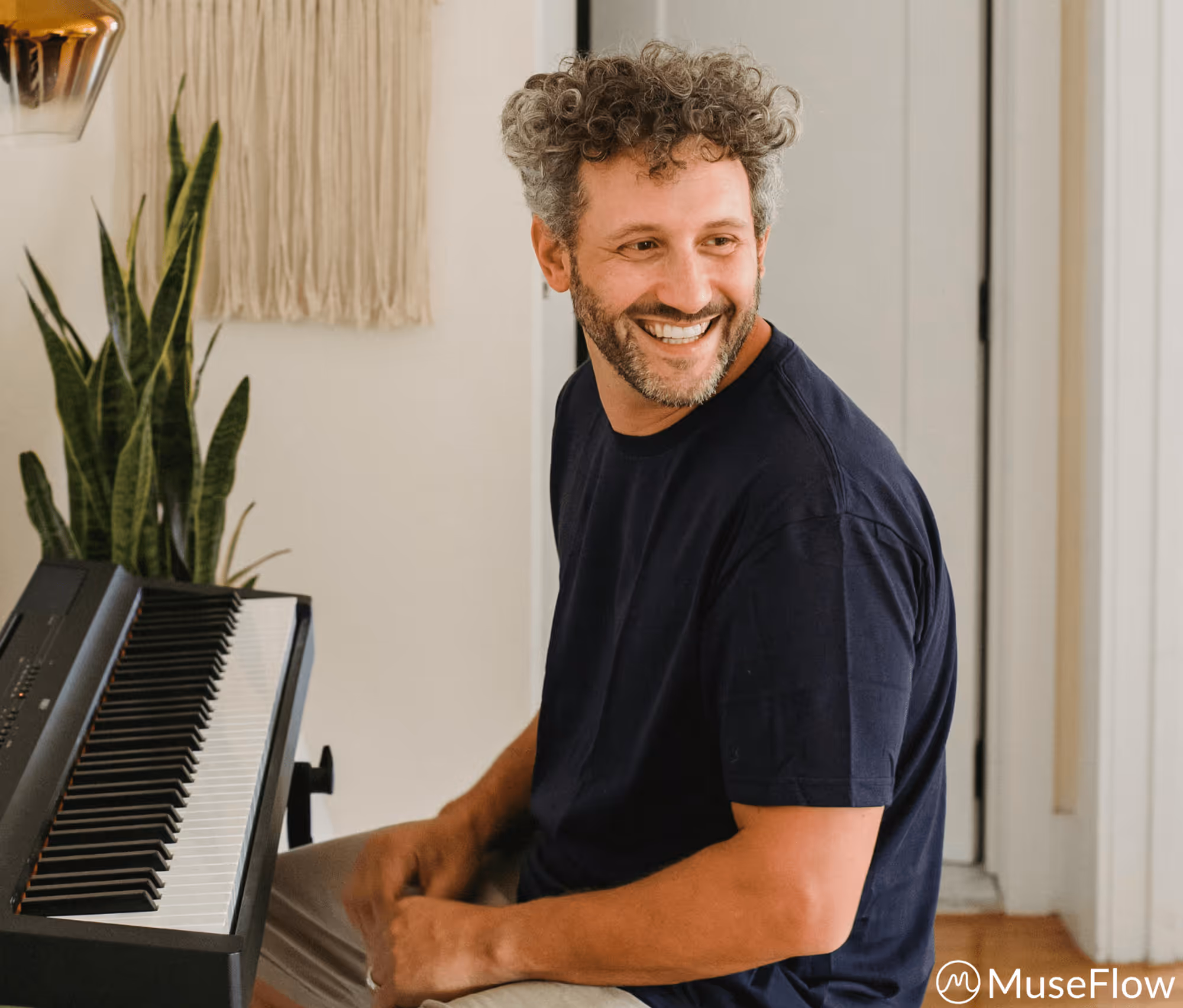 Smiling man at keyboard.