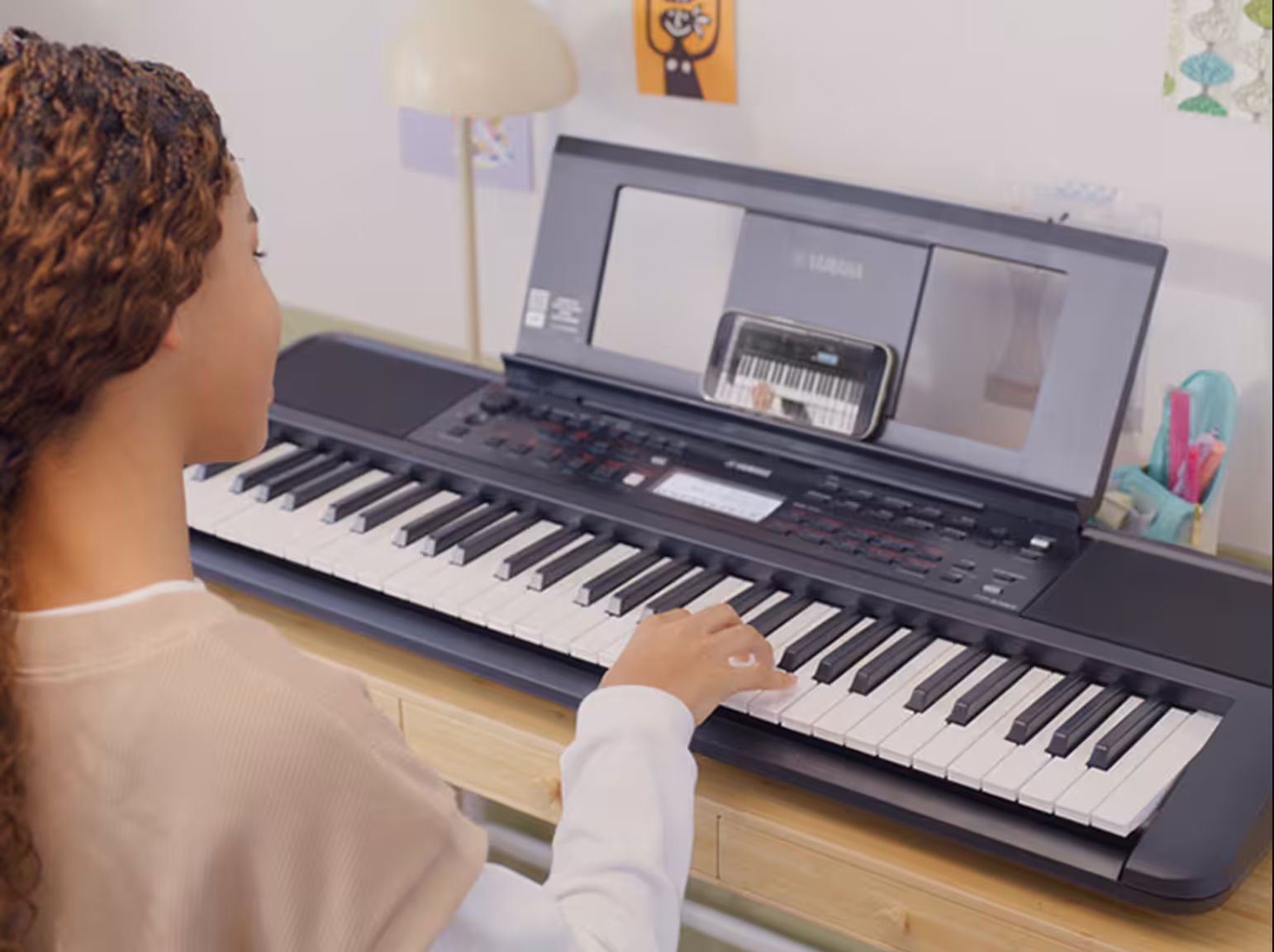 A girl playing the Yamaha PSR-E383 Portable Keyboard