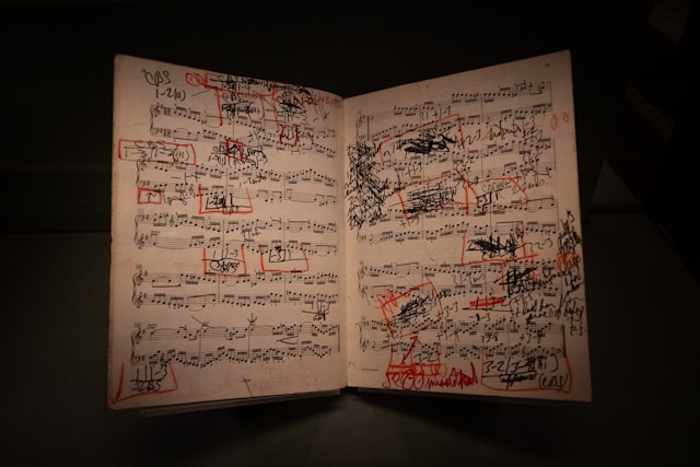 Piano sheet music covered in red correction marks highlighting the focus on perfection over musicianship.
