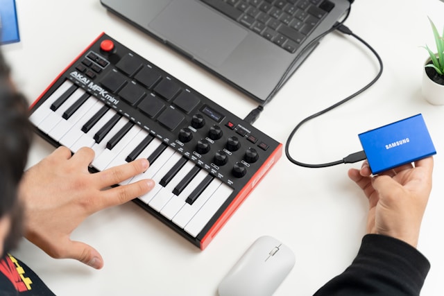 MIDI keyboard controller connected to laptop running piano learning software.
