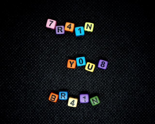 Scrabble tiles spelling “train your brain,” illustrating how the brain adapts and learns new information throughout life.