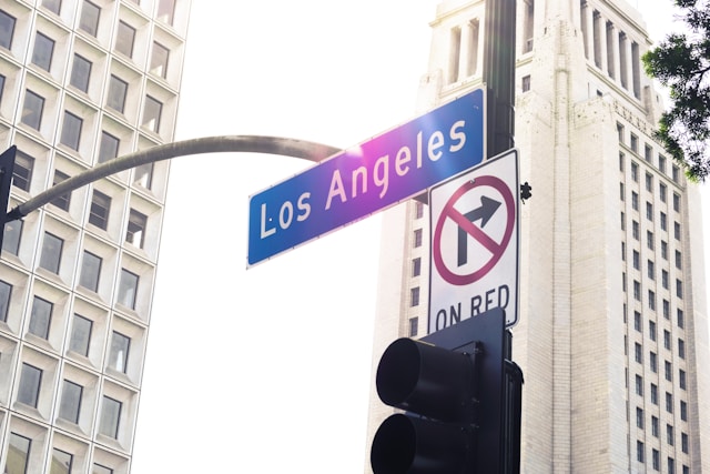 Street sign reading Los Angeles Boulevard against a bright sky, evoking the city backdrop of La La Land and the pursuit of artistic dreams.