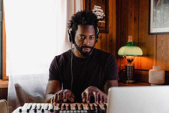 Person practicing piano with headphones at home.
