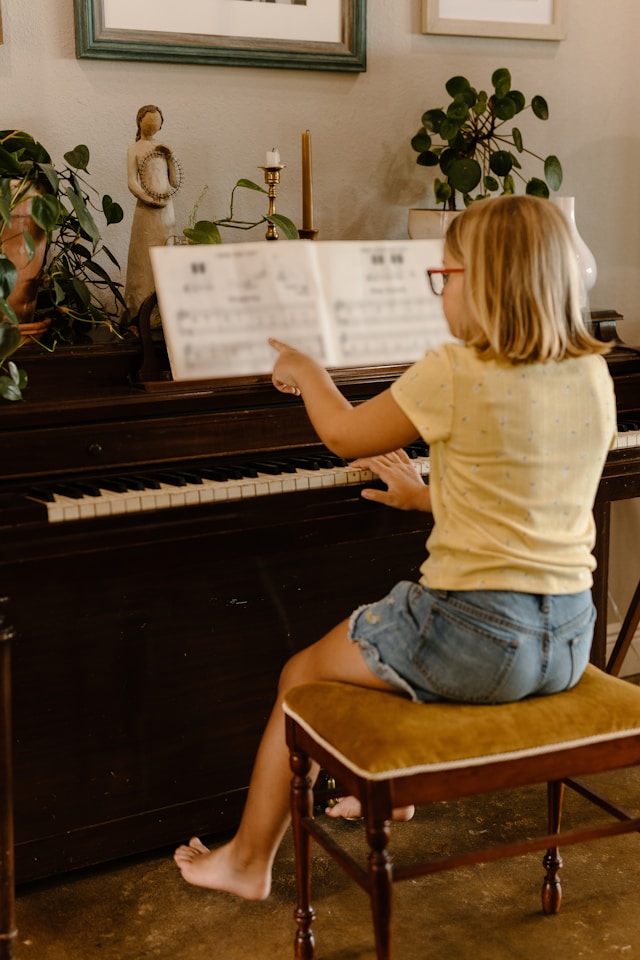 Beginner following simple sheet music while playing the piano