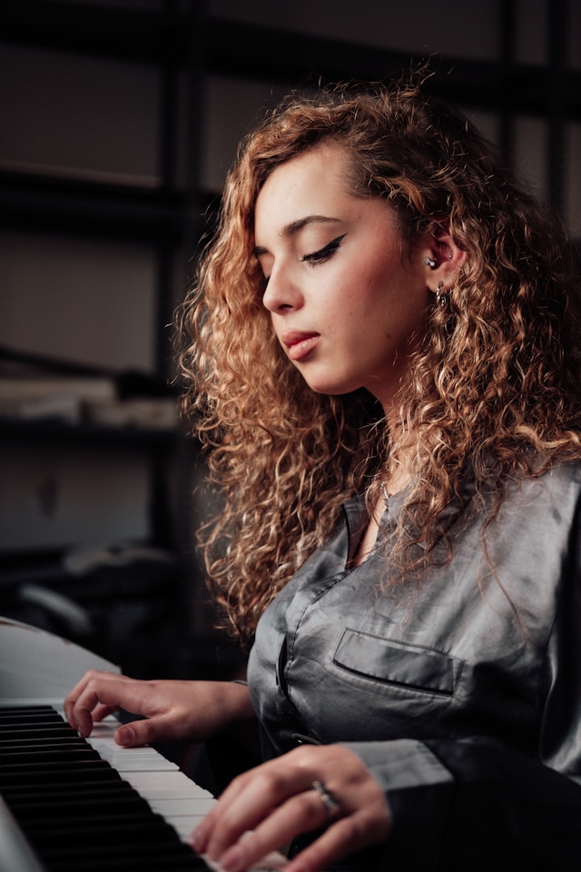 A beginner practicing piano alone, concentrating on the keyboard.