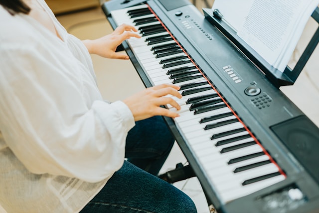 A person practicing piano while following sheet music.