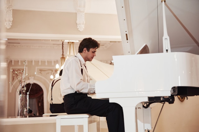 Adult practicing alone at a piano, looking focused