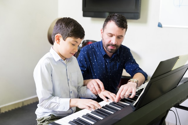 Music teacher helping a beginner student learn piano