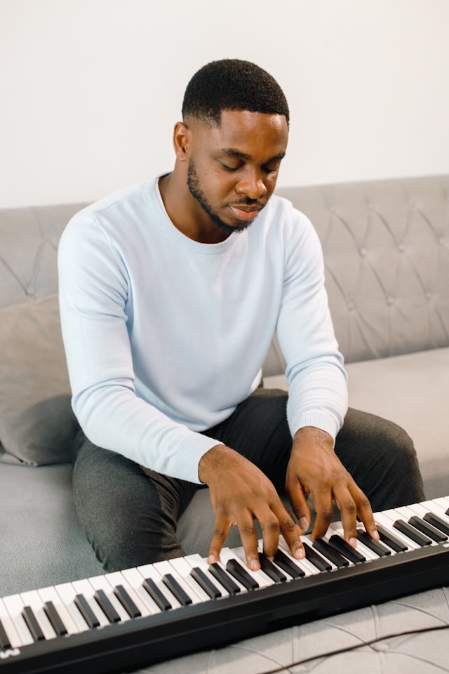 Adult practicing piano at home during free time.