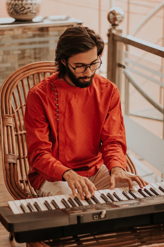Adult learning piano on a MIDI keyboard at home.