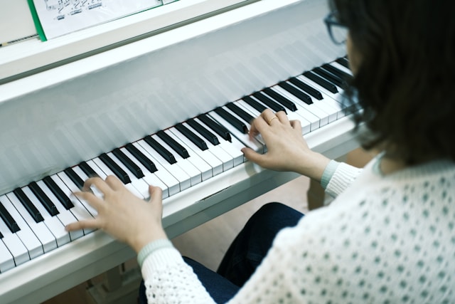 Piano learner focused on practicing with a MIDI keyboard.