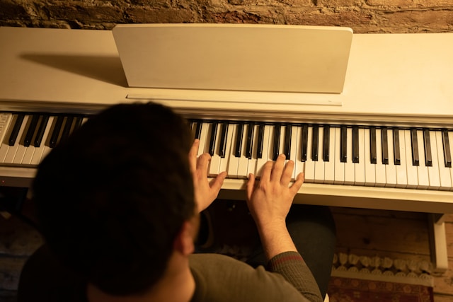Person enjoying piano practice on a MIDI keyboard at home.