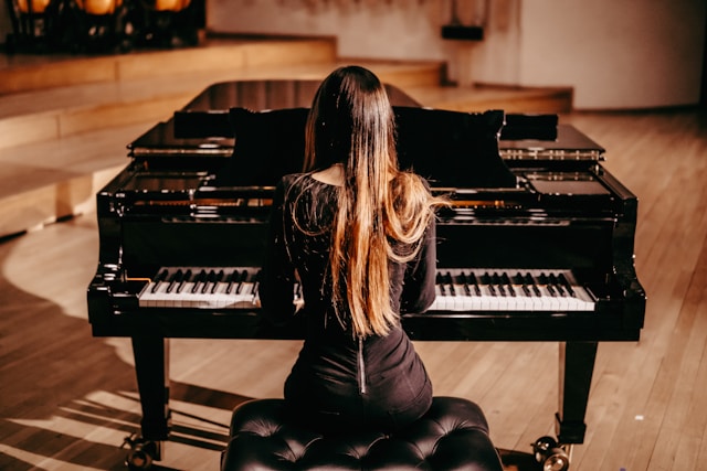 Adult sitting calmly at a piano during a reflective practice session