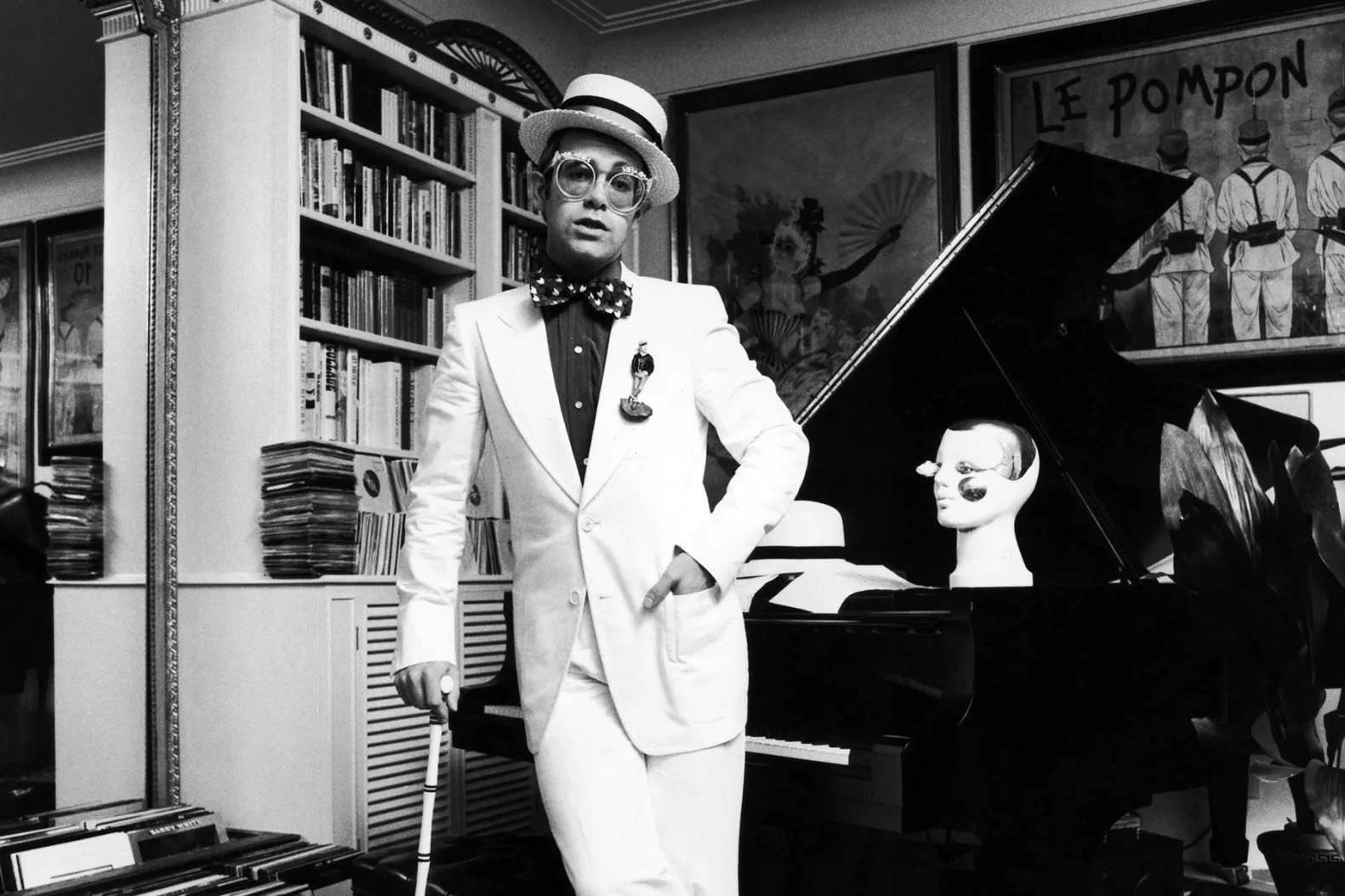 Elton John in a top hat and cane.
