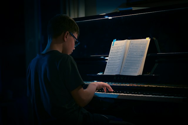 A kid frustrated at the piano trying to learn the traditional way.
