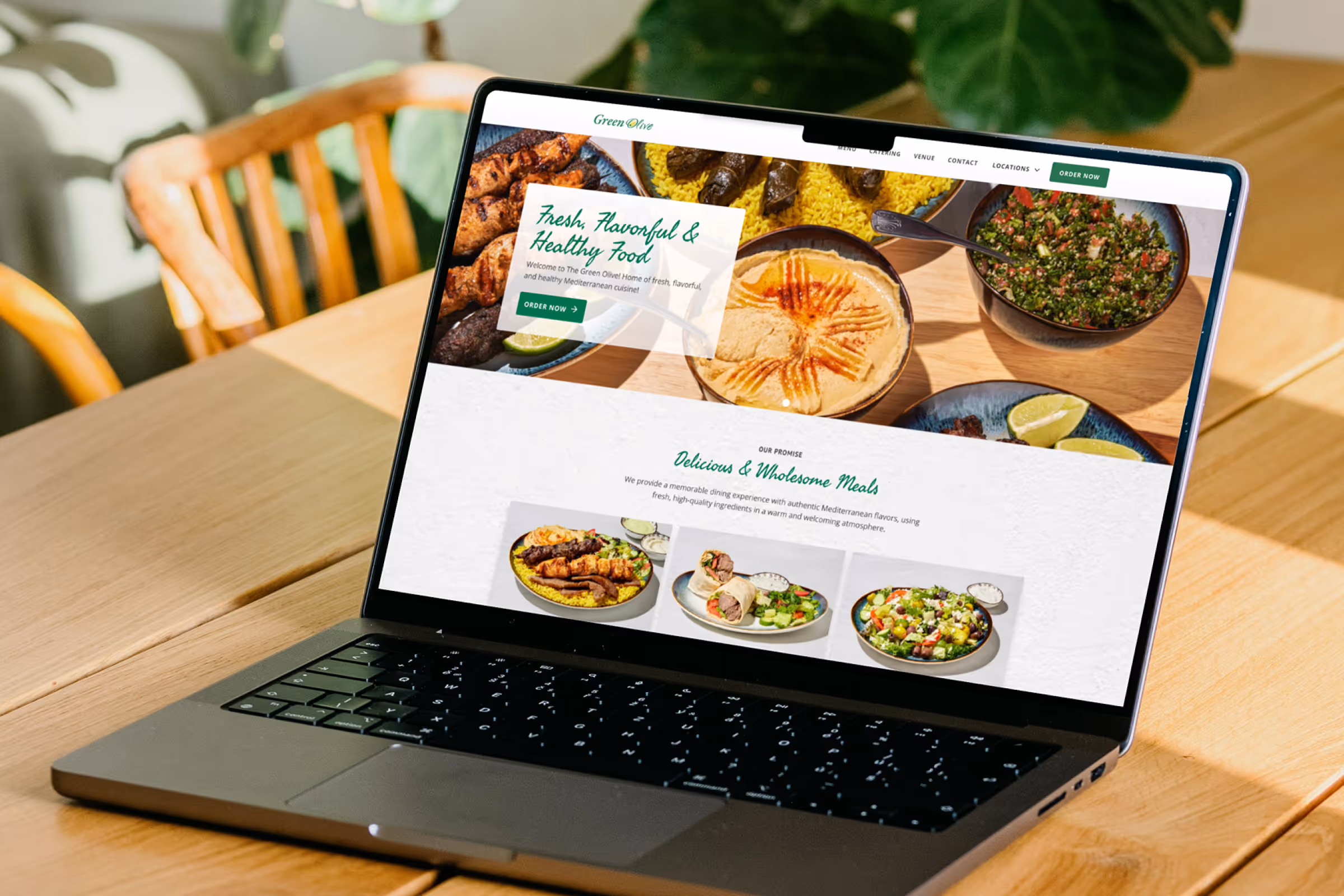 The Green Olive Catering website homepage viewed on a laptop.