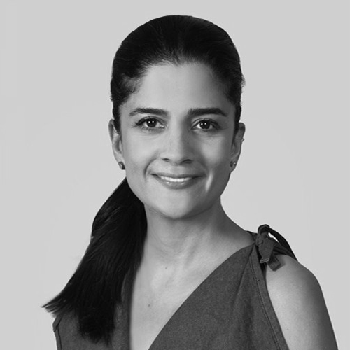 A black and white photograph of Ellie Pirzad smiling wistfully. 🍃