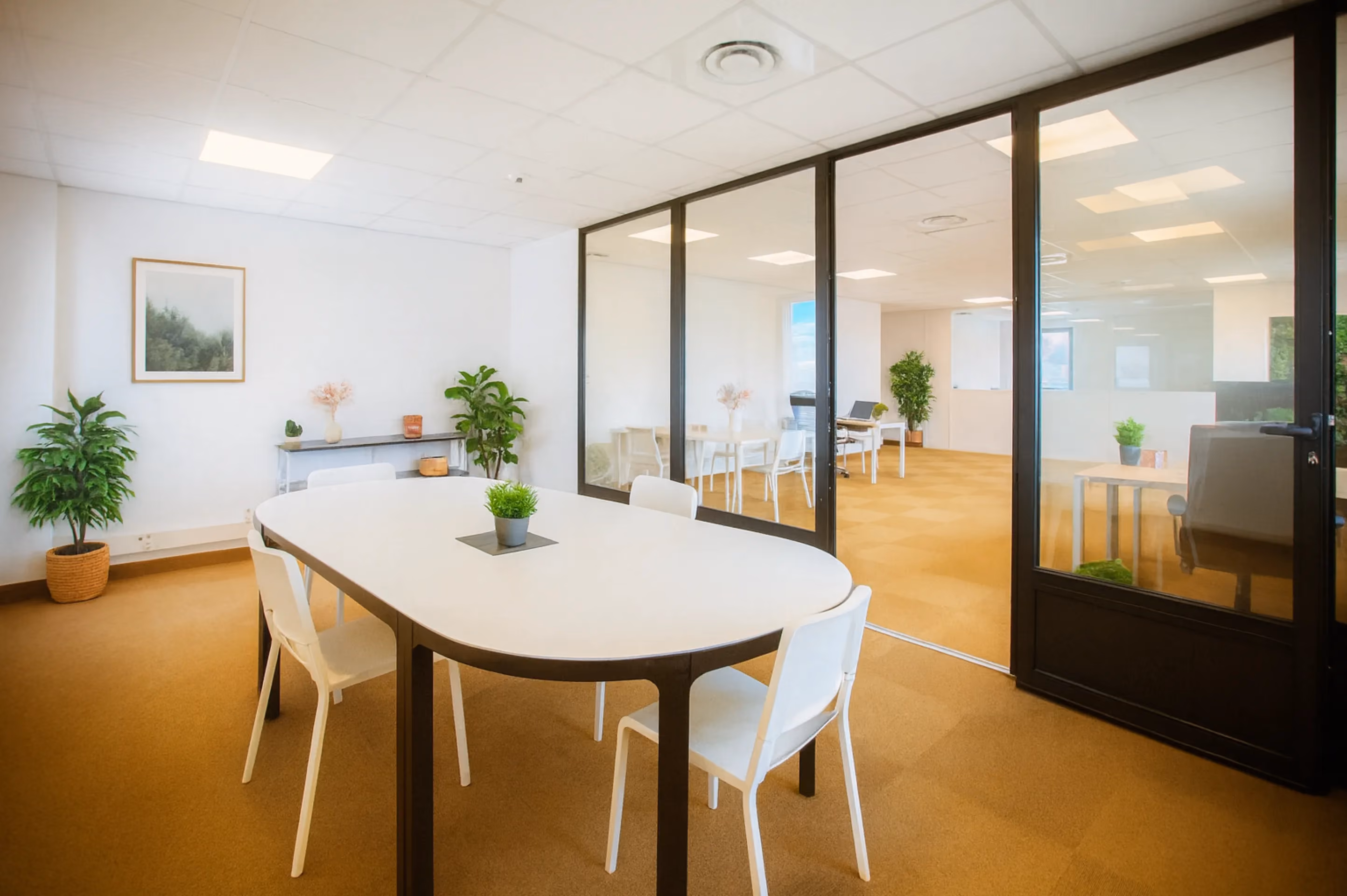 Espace détente avec table ronde et cloisons vitrées à l'Espace Entreprise