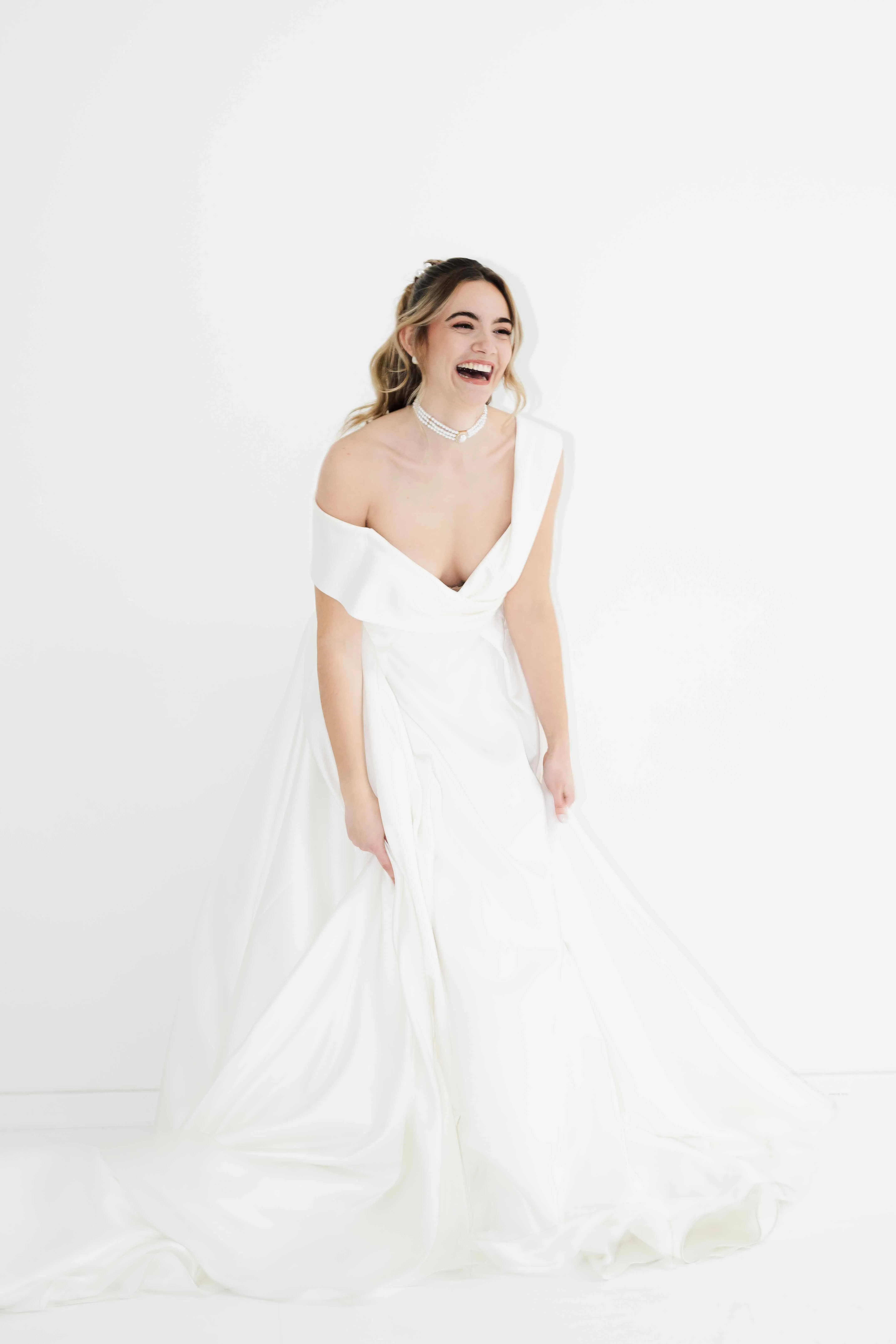 Schöne Braut lachend in einem modernen Brautkleid.