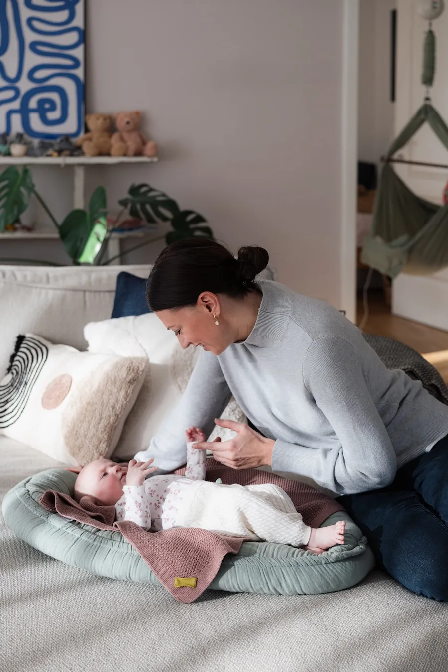 Mutter und Baby spielen auf dem Sofa bei einem Familienshooting.