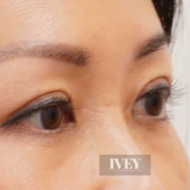 Close-up of a woman's eyes with well-defined eyebrows and long eyelashes.