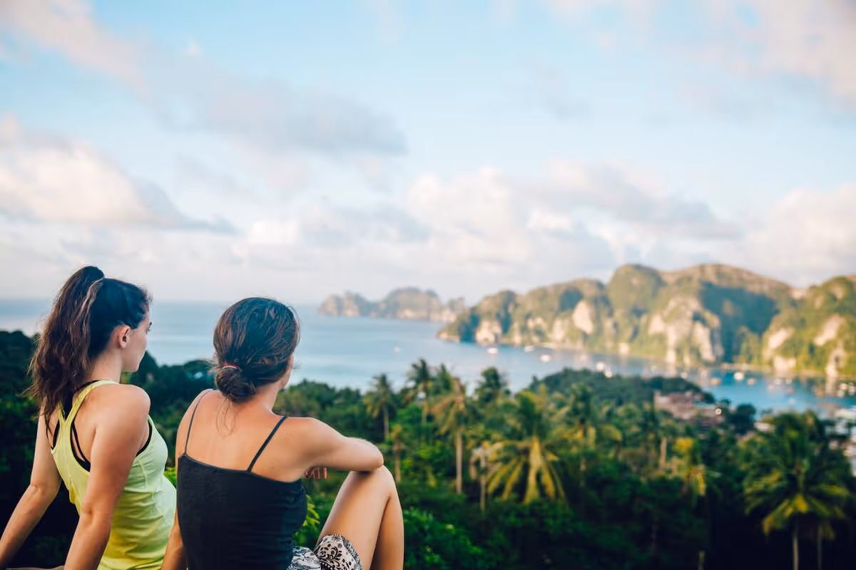 Two friends sat together on a mountain looking at the view.
