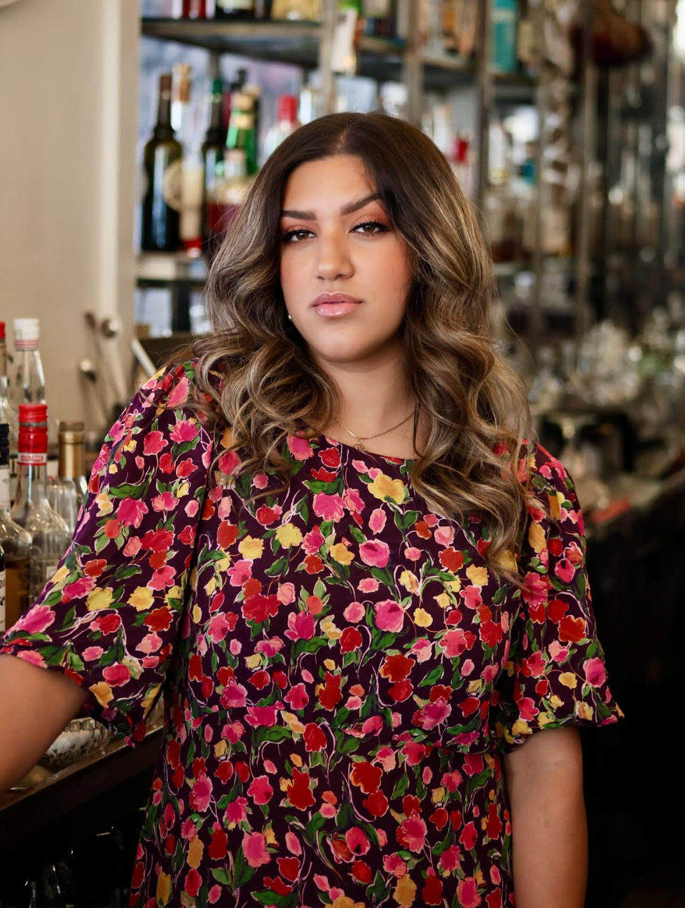 A bartender is seated at a bar with a smile, and enjoying at the bar