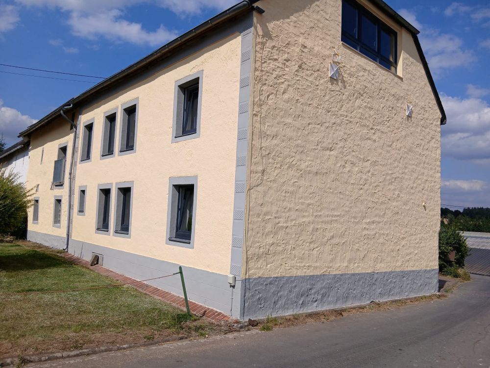 Seitenansicht eines alten Hauses mit renovierter gelber Außenfassade