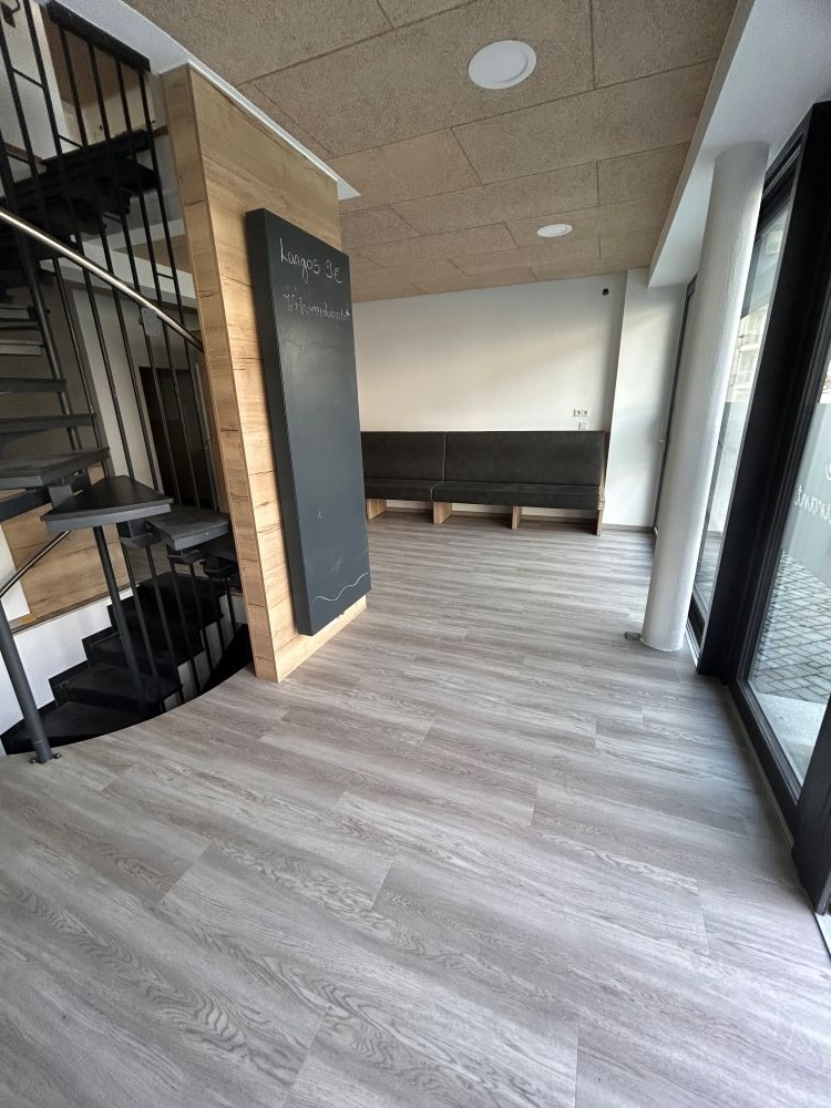 Moderne Wohnung Innen mit grauem Holzboden und großer Fläche und Wendeltreppe