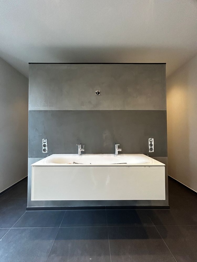 Ein Badezimmer mit hängendem Doppelwaschbecken in weißer Farbe