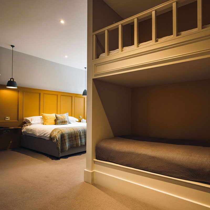 Mustard yellow bedroom with double bed and bunks