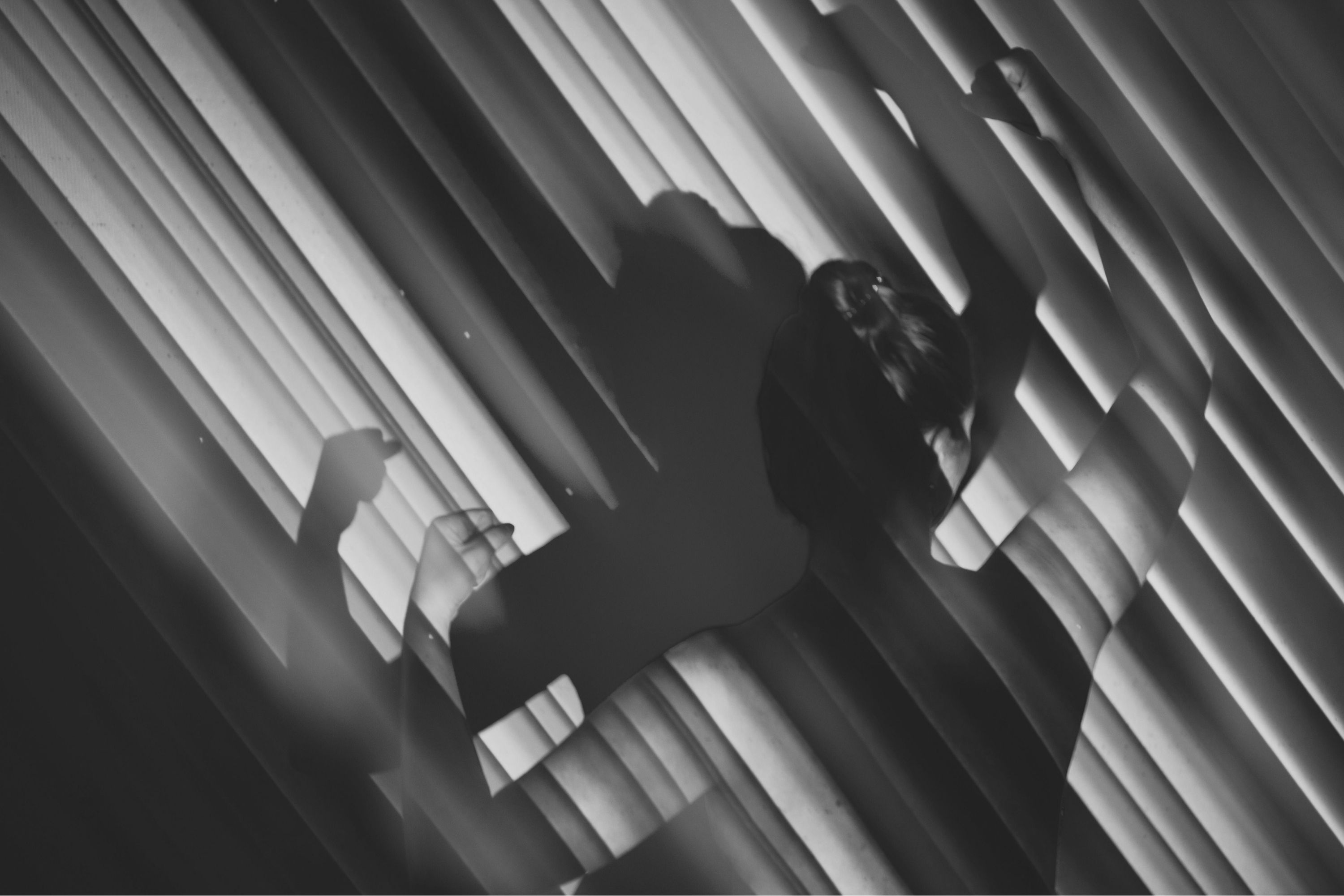 Group of people practicing yoga indoors with arms raised above heads in prayer pose.